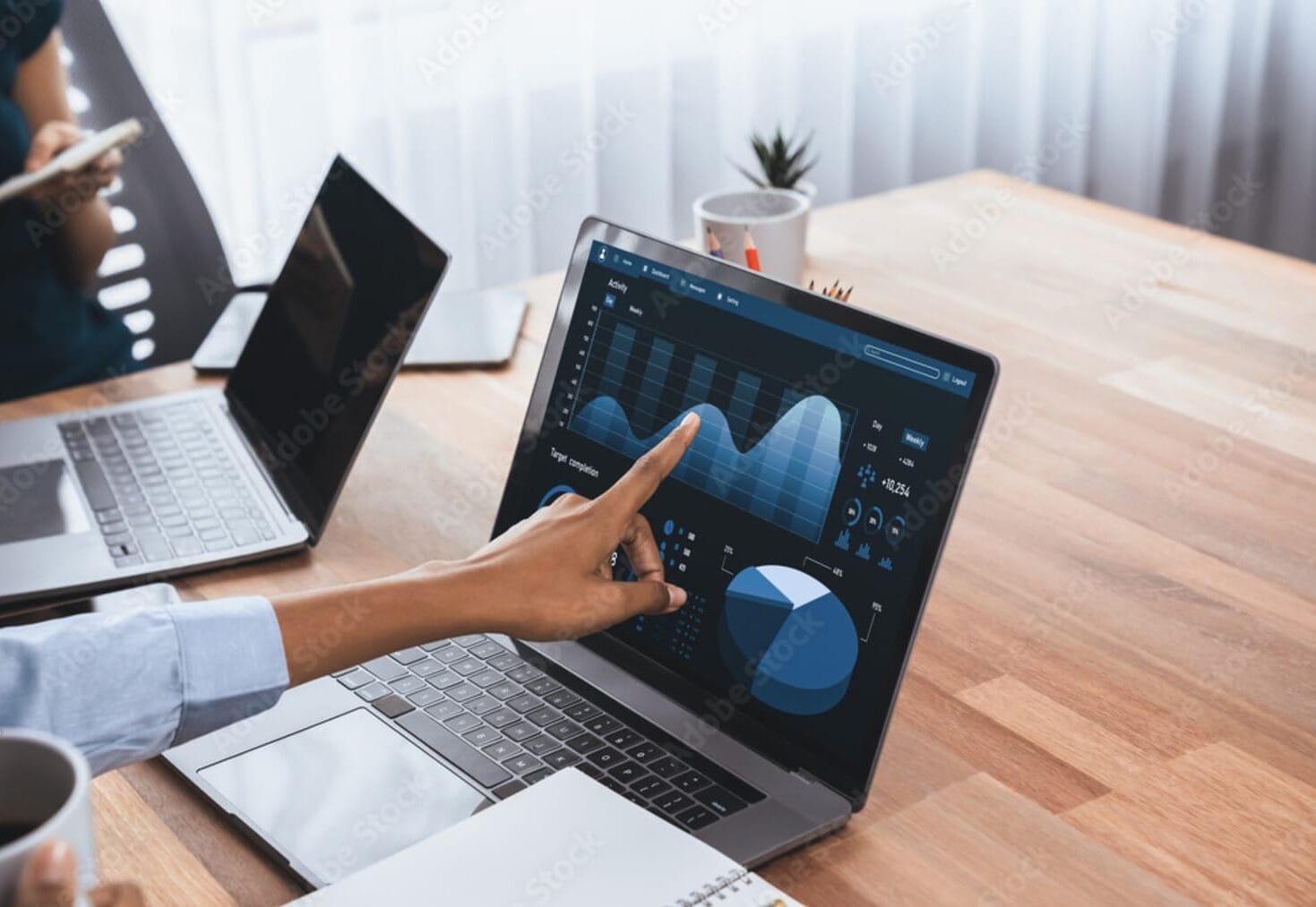 Photograph of analyst pointing at a report and data