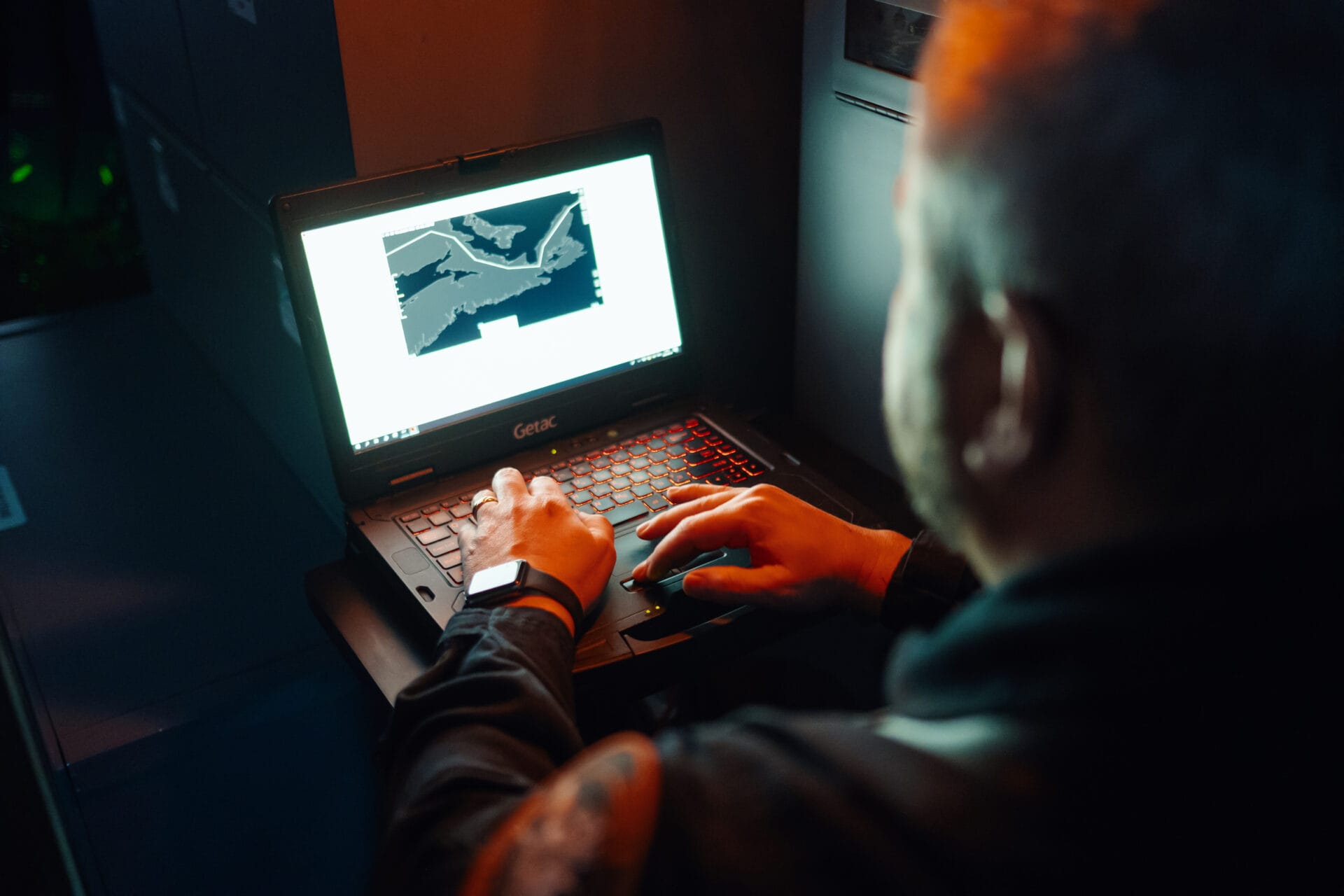 Photograph of an operator behind a laptop displaying a map