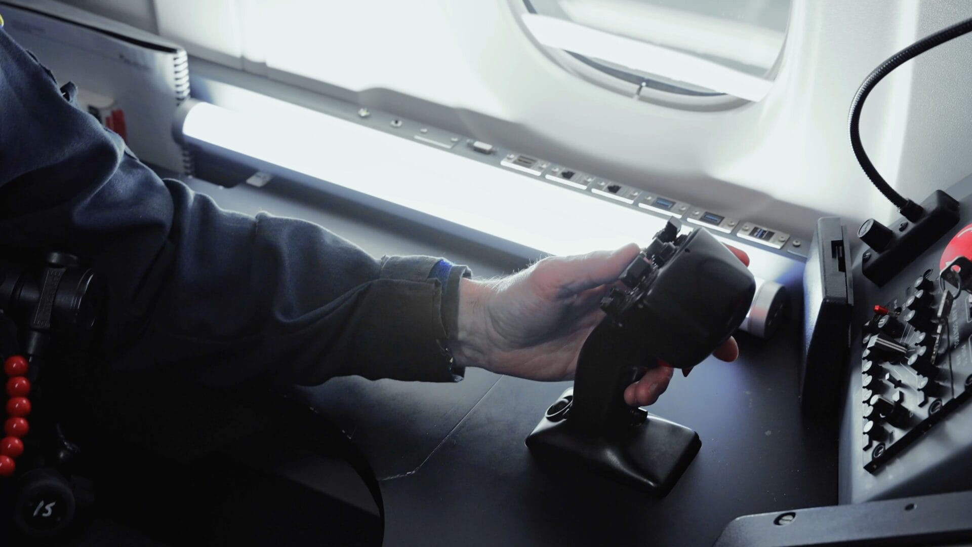 Sensor operators left hand on the joystick at the on-aircraft workstation