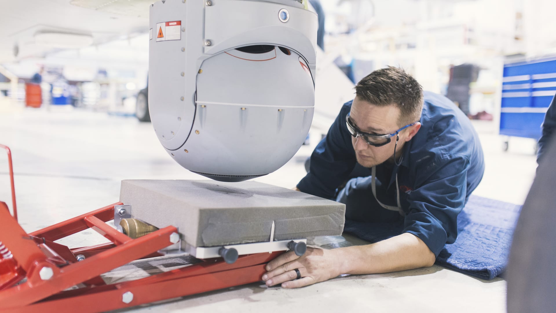 Photograph of AME installing an EO/IR camera on an aircraft